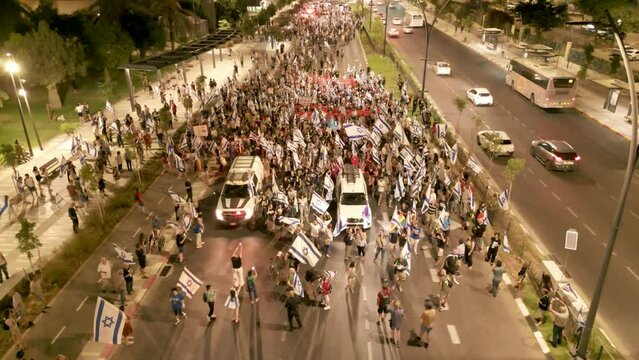 People crowd Protesting in the streets against the judicial overhaul reform, Beer Sheva, Israel, During sunset, aerial top from front view
