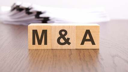 m and a letters on wood block cubes on wooden table, marketing concept - obrazy, fototapety, plakaty