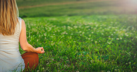 Woman doing yoga on the green grass at the mountain. Carpathians