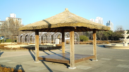 Rest place with a straw roof in an outdoor park