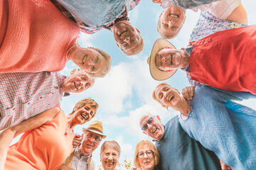 senior people having fun - bottom view of happy older people in a circle - friendship and leisure at the third age
