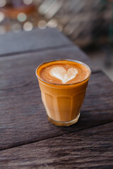 Delicious cappuccino with foam in a mug on a wooden table