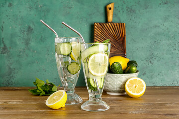 Glasses of lemonade with cucumber and mint on wooden table