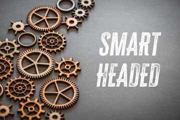 Smart Headed, small precise mechanisms, gears like clockwork, And text on a beautiful gray background, Smart Headed, The concept of development and creative operation of the company