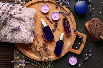 Composition with cosmetic products, spa accessories and lavender flowers on dark background