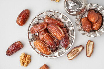 Bowls with dried dates on light background