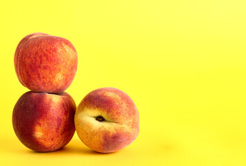 Sweet peaches on yellow background