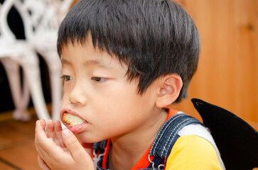 おやつをほおばる子供