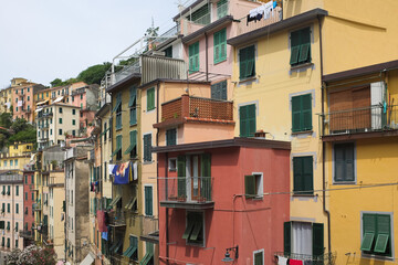 Cinque Terre, Italy - view of colorful houses with green windows in Riomaggiore, a seaside town on the Italian Riviera. Summer travel vacation background. Postcard from Europe. Architecture exterior.