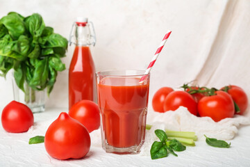 Glass of tasty tomato juice on white background