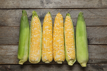 Fresh corn cobs on wooden background