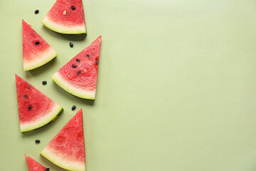 Composition with pieces of ripe fresh watermelon on green background