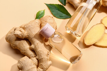Bottles of ginger cosmetic oil and leaves on yellow background