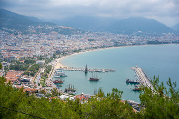 Aerial view resort city Alanya with harbor and beach in southern coast of Turkey in cloudy day
