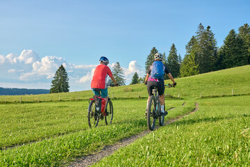 two senior girlfriends having fun during a cycling tour in the Allgau Alps near Oberstaufen,...