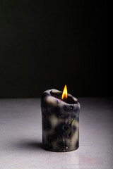black candle burns on a black background, isolated