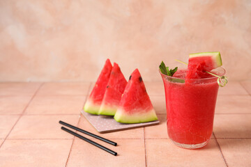Glass of tasty watermelon juice with mint on pink tile table