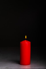 red candle burns on a black background, isolated