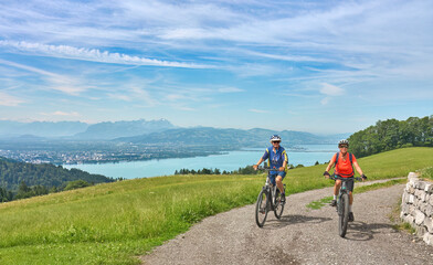 two senior girl friends having fun during a cycling tour above Lake Constance, Bregenz,Vorarlberg, Austria - obrazy, fototapety, plakaty