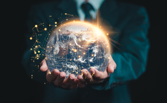 Businessman holding the world in hands, global network communication with international connections for business. Elements of this image furnished by NASA