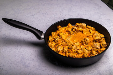 Turkey goulash in a frying pan on a white background