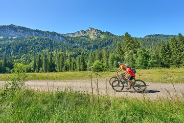 two senior girl friends having fun during a cycling tour in the Bregenz Forest near Sibratsgfäll, Vorarlberg, Austria