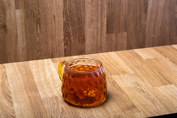 golden cup of tea in wooden interior