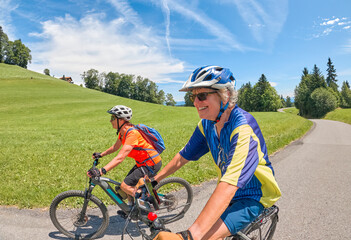 two senior girl friends having fun during a cycling tour in the Bregenz Forest near Sibratsgfäll, Vorarlberg, Austria