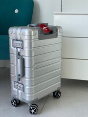 valise alu avant départ devant commode