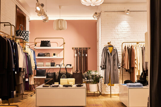Background image of elegant clothing boutique interior with clothes and accessories on display, copy space