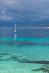 Bateau sur la mer en Corse du sud, eau turquoise et nuages menaçants