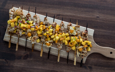 Fototapeta na wymiar Top down view of grilled chicken skewers topped with a fresh golden berry salsa.
