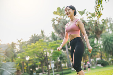 fit Asian woman in her 30s wearing pink sportswear, exercising in a public park at sunset. Immerse yourself in concept of wellness and well-being with inspiring display of a healthy outdoor lifestyle.