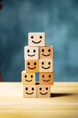 Stack of wooden blocks with faces drawn on them sitting on table.