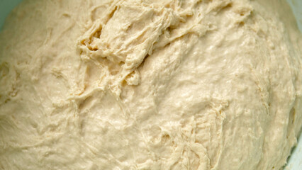 freshly kneaded dough in a basin, close-up freshly fermented dough,