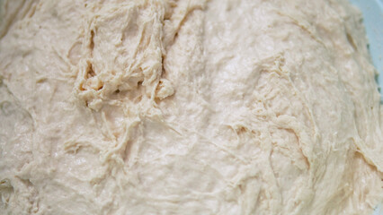 freshly kneaded dough in a basin, close-up freshly fermented dough,