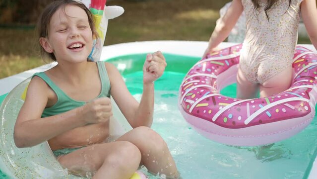  Group of Little Girls of Various Ages Play and Have Fun in a Pool