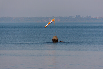 A windsock or wind cone pointing the direction of the wind in the middle of the sea