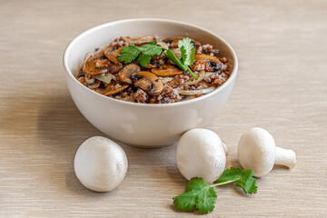 home-made buckwheat porridge with mushrooms in a ceramic bowl