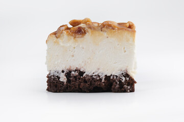 A piece of cheesecake with peanuts and caramel on a white background