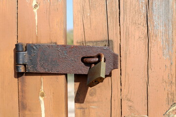 An old padlock hangs on the gate.