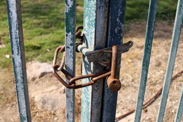An old padlock hangs on the gate.
