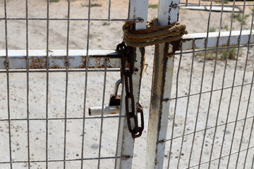 An old padlock hangs on the gate.
