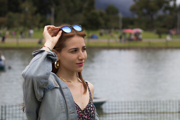 Teen young girl woman near lake,river, meditating,relaxing and smiling in simon bolivar Park in Bogota Colombia.inspiration nature beauty harmony landscape outdoors. - obrazy, fototapety, plakaty