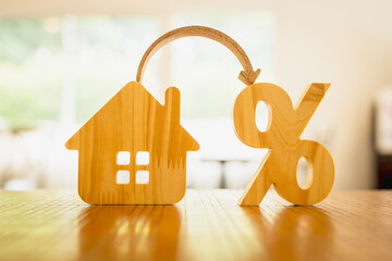 Percentage and house sign symbol icon wooden on wood table. Concepts of home interest, real estate, investing in inflationม home loan interest rate hike.