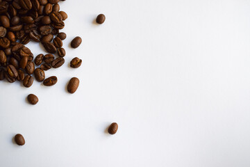 Roasted coffee beans in the upper corner on a white horizontal background with copy space for text....