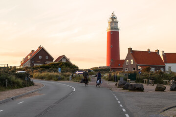 Two cyclists ride past the lighthouse on the Dutch island of Texel.
