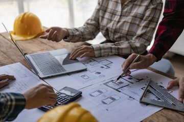 Engineers point to buildings on blueprints and use building design laptops, construction projects...
