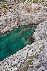 Small enclosed bay with emerald green waters at Korakonissi islet in the island of Zakynthos, in the Ionian Sea, Greece, Europe. It's a beautiful spot for swimming, popular among guests. 