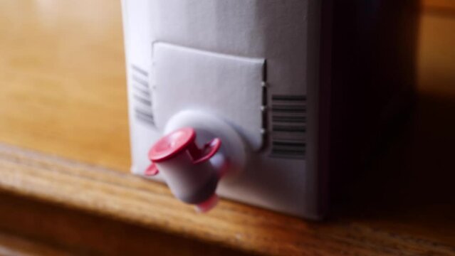 A bag of wine in a carton box. Bag-in-box or BiB is a container for the storage and transportation of liquids with tap. Strong bladder or plastic bag seated inside a corrugated fiberboard box
